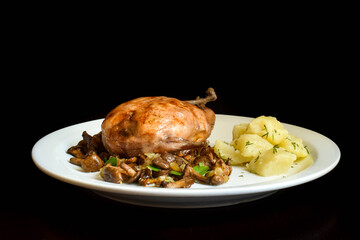 Baked mushrooms stuffed quail with fried chanterelles.