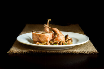 Baked mushrooms stuffed quail with fried chanterelles.