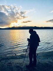 Obraz premium カメラマンの男性 夕焼け 湖のほとり