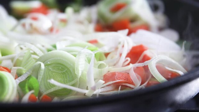 Leak and carots cooking in steaming pan