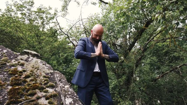 Businessman practicing martial arts bowing head to prayer hands