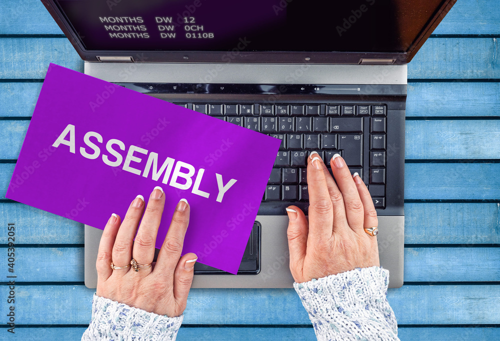 Poster assembly programming language. paper width word assembly and laptop,