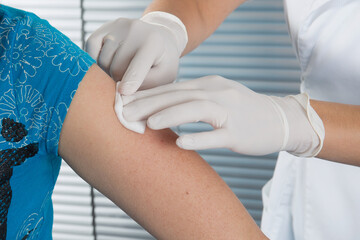 woman doctor making a vaccination injection with a syringe at hospital