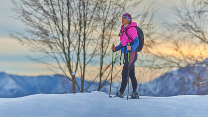 beautiful young woman rests during a snowshoe trek