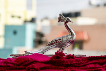 Beautifully design and carved silver peacock statue , on blur background.