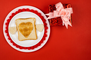 Heart shaped toast in a toasted rye bread slice on a white ceramic plate. Valentine's day concept. Love the breakfast design. Festive lunch or breakfast. Copy space. Gift