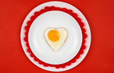 heart shaped egg.Festive breakfast, lunch.Valentine's Day. On a red background. Place for your text.