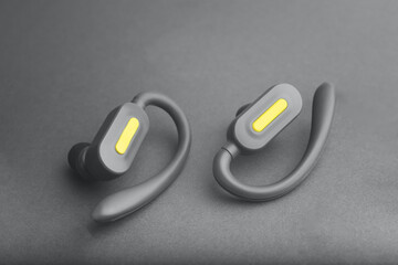 Wireless grey headphones with yellow details on the grey background. Trendy color. Color 2021.