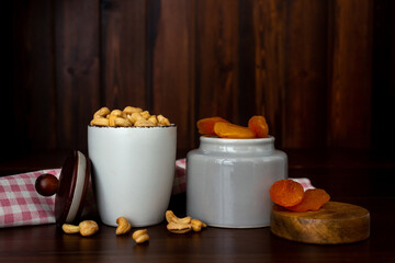 Bowls with cashew nuts and dried apricots on wooden table. Dried fruits and nuts concept