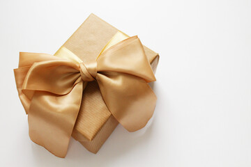 Christmas gift in craft paper isolated at white background. Gift box with gold ribbon.