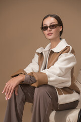 The glamorous young woman in leather jacket posing