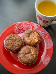 plate with muffins and mug with orange juice