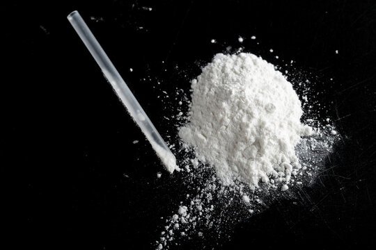 ketamine drugs and plastic straw on black wood background.Drug epidemic concept