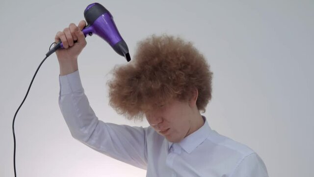 Curly Guy Dries His Hair With A hairdryer