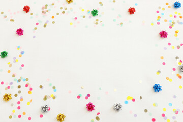 Obraz na płótnie Canvas Party colorful confetti over white wooden background . Top view, flat lay