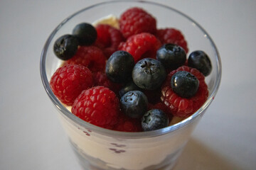 Nachtisch mit Sahne Himbeeren und Heidelbeeren