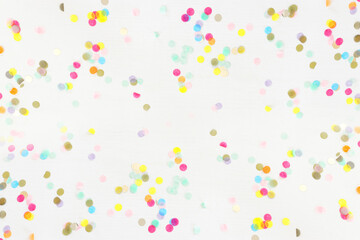 Fototapeta na wymiar Party colorful confetti over white wooden background . Top view, flat lay