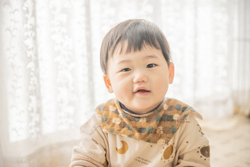 リビングでリモコンで遊ぶ赤ちゃん