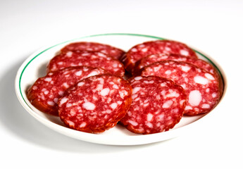 Sliced salami sausage close-up on a plate.