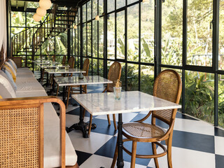 Interior design of coffee shop with big glass windows to the garden view.