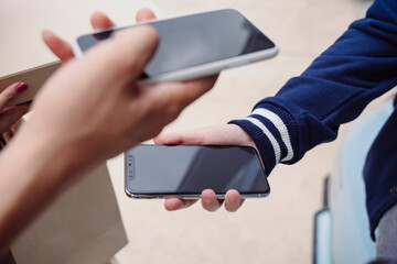 Close up hand of delivery mand and customer paying cost with mobile application with smartphone.