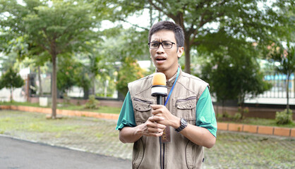 Fototapeta premium asian male journalist wear vest and ready for news