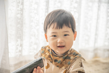 リビングでリモコンで遊ぶ赤ちゃん