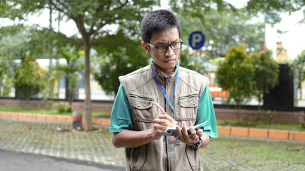 Fototapeta premium asian male journalist wear vest and ready writting for news