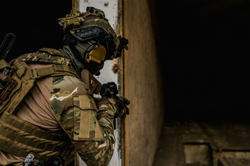 Special forces soldier doing tactical training in building clearing (CQB). He is wearing multicam uniform and assault rifle HK416.