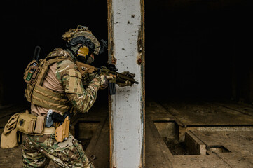 Special forces soldier doing tactical training in building clearing (CQB). He is wearing multicam...