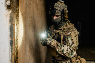 Special forces soldier doing tactical training in building clearing (CQB). He is wearing multicam uniform and XDM 9mm gun.