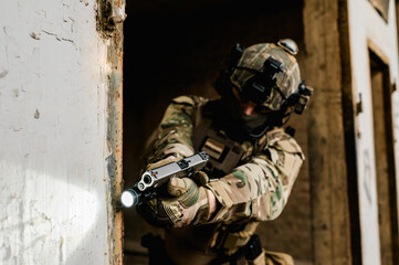 Special forces soldier doing tactical training in building clearing (CQB). He is wearing multicam...