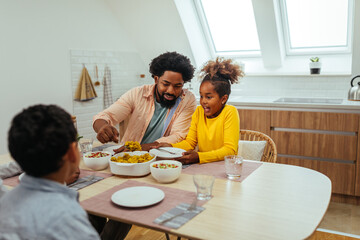 Fototapeta na wymiar Afro family eating together at home