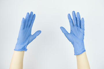 hands in rubber medical gloves raised up close up