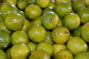 Piles of Bright Green Limes for Sale at Outdoor Market