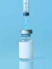 Vaccine in a bottle with a syringe on a blue background.The concept of medicine, healthcare and science.Coronavirus vaccine.Copy space for text.