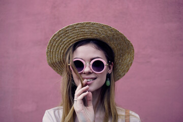 Pretty woman in sunglasses and hat smile attractive look pink background