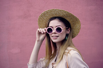 Pretty woman in sunglasses fashion hat walk pink wall