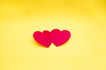 Two red hearts together on a yellow background. Lovers hearts.