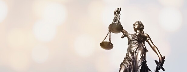 Lady justice - blindfolded figurine. Low angle view.  Panoamic image wih copy space.	