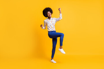 Full length photo of adorable lucky dark skin lady dressed casual outfit rising fists isolated yellow color background