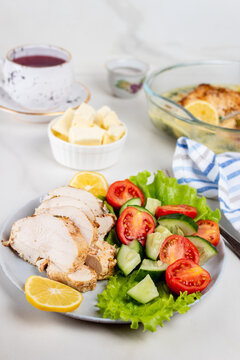 Chicken breasts with lemon sauce. Sliced chicken and fresh vegetable salad.