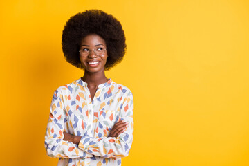 Obraz na płótnie Canvas Photo of cute sweet dark skin lady dressed casual outfit glasses arms folded looking empty space isolated yellow color background