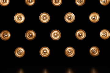 Lighting background. Many light bulbs in  light modifier on black wall.