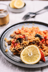 Arroz con verduras y azafran, spanish dish. Vegetarian risotto with  vegetables, champignons and saffron on beige linen tablecloth. Selective focus