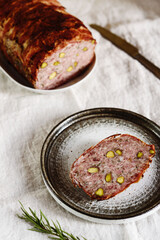 Terrine. Meatloaf. Traditional French cuisine loaf of meat, similar to a pâté, with bacon and pistachios. Selective focus