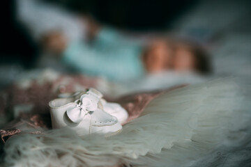 Fototapeta na wymiar Elegant little baby girl shoes for her Christening. 