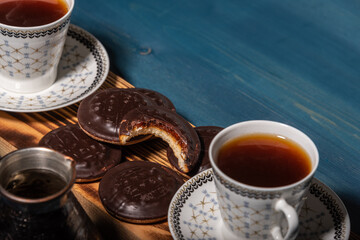 Two cups of coffee, chocolate cookies and cezve on a wooden table. Breakfast for two.
