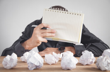 Man working in office. Crumpled paper balls on the table