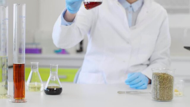 Chemist working with hemp CBD oil and tablet in laboratory